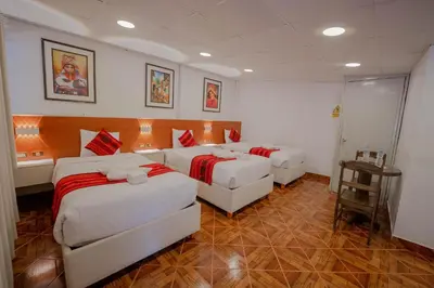 a hotel room with two beds and a table at DANNA INN in Machu Picchu