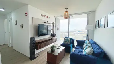 a living room with a blue couch and a tv at Depa playa San Bartolo 3 camas piscina wifi juegos in Lima