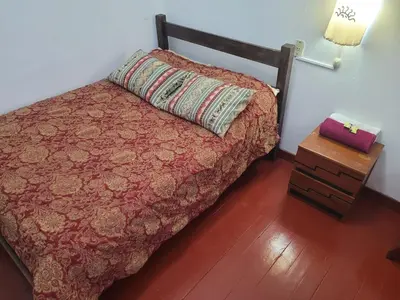a bedroom with a bed with a pillow and a night stand at Hostal CASA CUSCO in Cusco