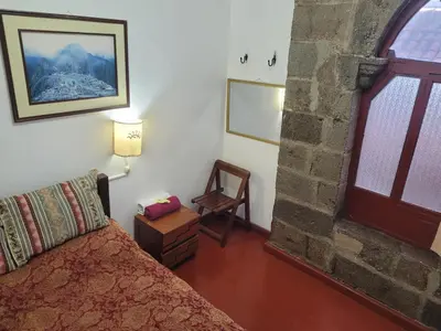 a bedroom with a bed and a stone wall at Hostal CASA CUSCO in Cusco