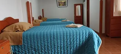 two beds with blue blankets in a bedroom at Casa Tejedora in Chinchero