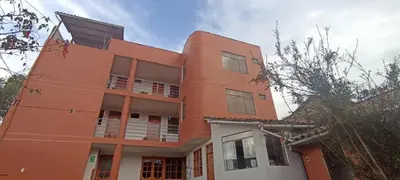 an orange building with a lot of windows at Casa Tejedora in Chinchero