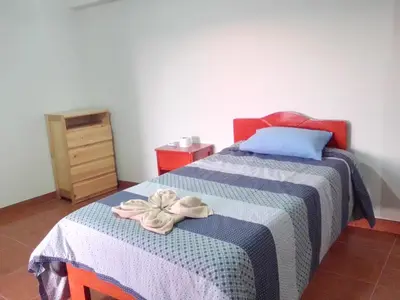 a bedroom with a bed with a blue and white blanket at Casa Tejedora in Chinchero