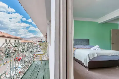 a bedroom with a bed and a balcony with a view at Templo de la Luna in Cusco