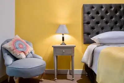 a bedroom with a bed and a chair and a lamp at Templo de la Luna in Cusco