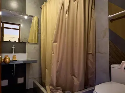 a bathroom with a shower curtain and a toilet at Santuario Machupicchu in Machu Picchu