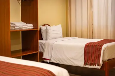 a hotel room with two beds and a mirror at Santuario Machupicchu in Machu Picchu
