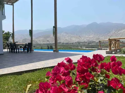 a bunch of pink flowers in front of a pool at Mirador del Paraiso in Lunahuaná