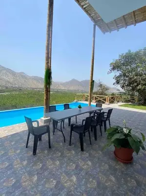 a table and chairs in front of a pool at Mirador del Paraiso in Lunahuaná