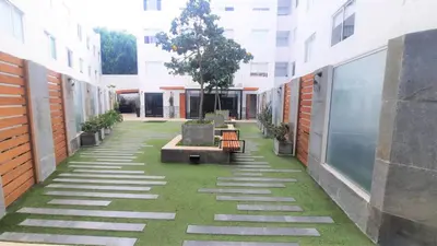 a courtyard with benches and a tree in a building at Hermoso y céntrico 1BR en Barranco con cochera wifi y netflix in Lima