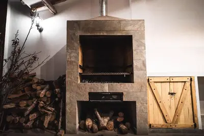 a stone fire place in a room with logs at Hermosa casa en Valle Sagrado in Cusco