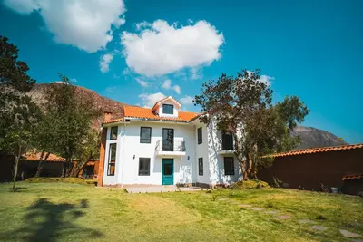 a white house with an orange roof at Hermosa casa en Valle Sagrado in Cusco