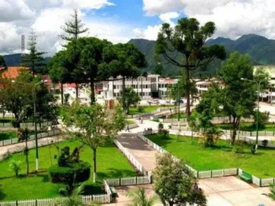 a park with trees and buildings in a city at HOSPEDAJE D`NOA En el centro de Oxapampa in Oxapampa