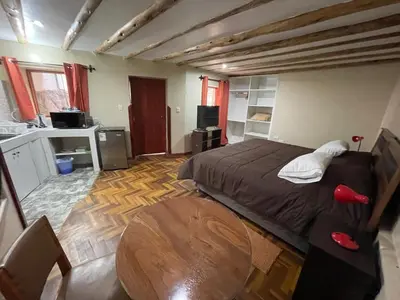 a bedroom with a bed and a table in it at Anka Wasi Lodging in Cusco
