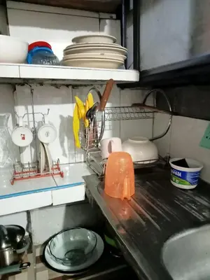a kitchen counter with a sink and dishes on a shelf at POSADA ISABELITA in Lima