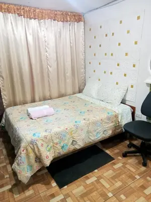 a bedroom with a bed and a window and a chair at POSADA CHABELITA in Lima