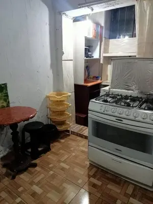a kitchen with a stove and a table at POSADA CHABELITA in Lima