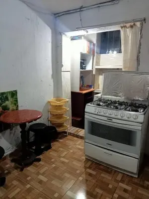 a kitchen with a stove and a table at POSADA CHABELITA in Lima