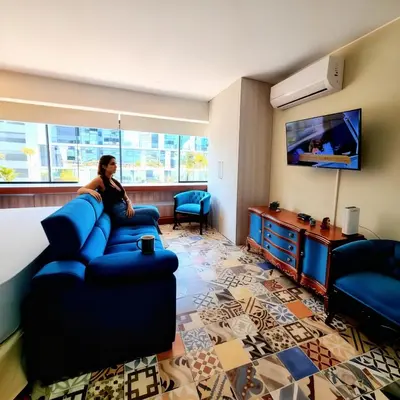 a woman sitting on a couch in a hotel room at San Isidro Suites Basadre 1B403 in Lima
