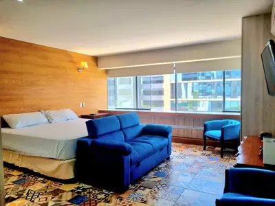 a hotel room with a bed and a blue couch at San Isidro Suites Basadre 1B403 in Lima