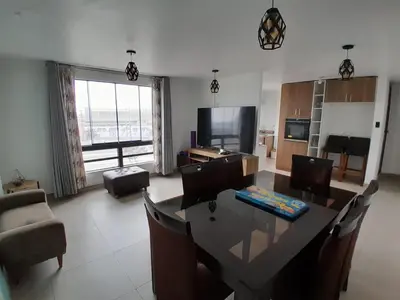 a living room with a table and chairs and a television at HOME BLESSED II in Lima