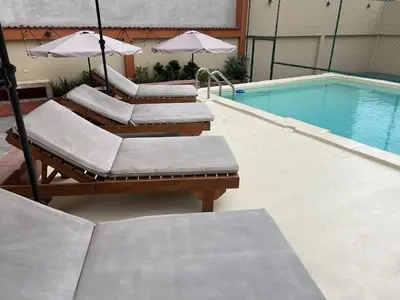 a group of lounge chairs with umbrellas next to a swimming pool at APARTAMENTO COMPLETO EN LA MEJOR ZONA DE MIRAFLORES in Lima
