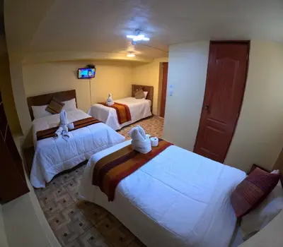 a hotel room with two beds and a television at LA JOYA DE SAN BLAS in Cusco