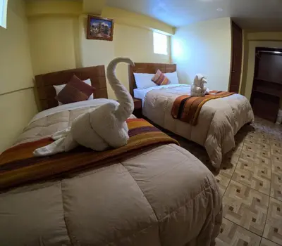 two stuffed animals sitting on beds in a hotel room at LA JOYA DE SAN BLAS in Cusco