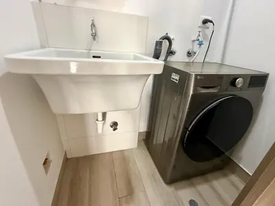 a bathroom with a sink and a washing machine at Departamento amoblado in Lima