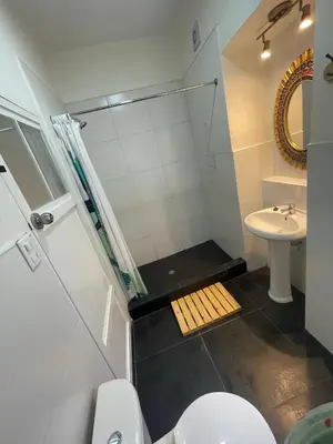 a bathroom with a shower and a toilet and a sink at Illa B&B in Cusco