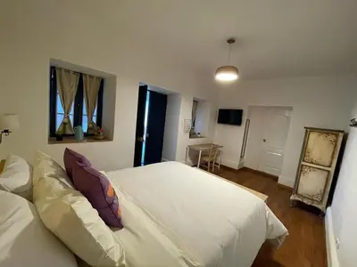 a bedroom with a large white bed in a room at Illa B&B in Cusco