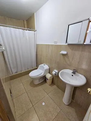 a bathroom with a toilet and a sink at Hospedaje Las Parraz in Ica