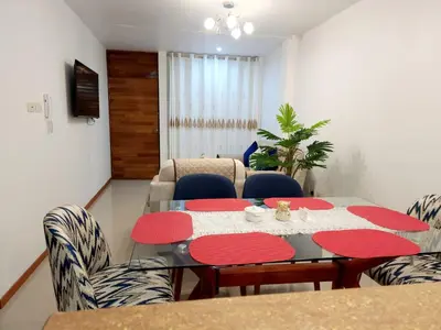 a living room with a dining room table and chairs at Departamento familiar en Huacachina in Ica
