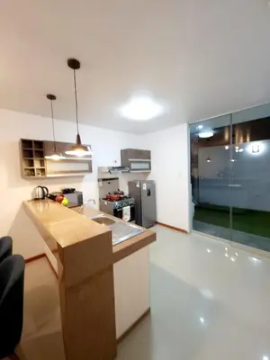 a kitchen with a counter top and a refrigerator at Departamento familiar en Huacachina in Ica