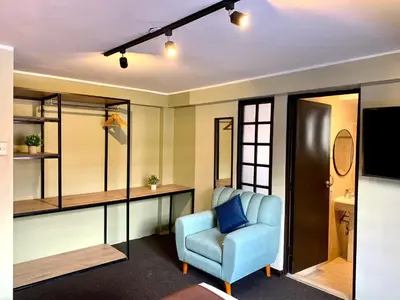 a room with a blue chair and a television at Apartamentos Montes in Cusco