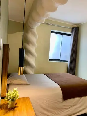 a bedroom with a large bed and a window at Apartamentos Montes in Cusco