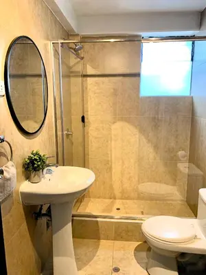 a bathroom with a shower and a sink and a toilet at Apartamentos Montes in Cusco
