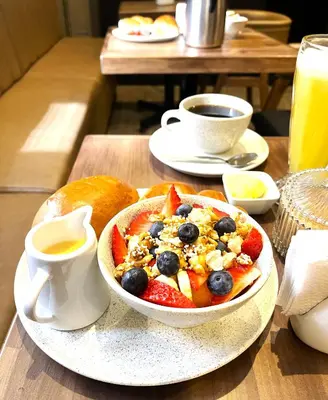 a table with a bowl of breakfast food and a cup of coffee at Apartamentos Montes in Cusco