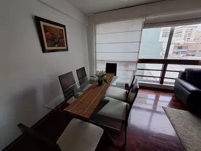 a living room with a dining table and a couch at Apartamento Temporal en Miraflores in Lima