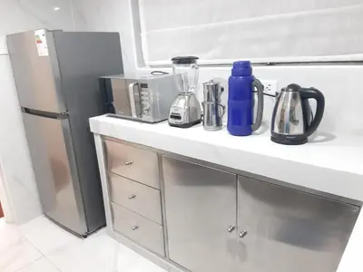 a kitchen counter with a blue bottle and a refrigerator at APARTAMENTO LINDO - A 2 Cuadras de la Plaza de Armas y del Palacio de Gobierno in Lima