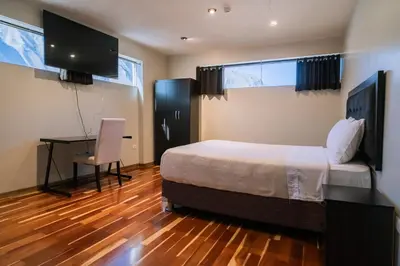 a bedroom with a bed and a desk and a computer at Hotel California Urubamba in Urubamba