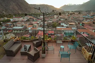 a balcony with chairs and a view of a city at Hotel California Urubamba in Urubamba