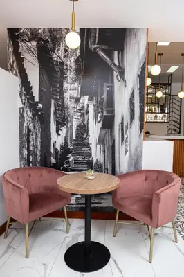 a dining room with two pink chairs and a table at Hotel San Blas in Lima