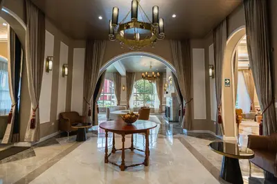 a lobby with a table and a chandelier at Hotel de Turistas Huancayo - Hotel Asociado Casa Andina in Huancayo