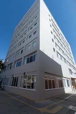a large white building with windows on a street at Hotel Presidente Huancayo - Asociado Casa Andina in Huancayo