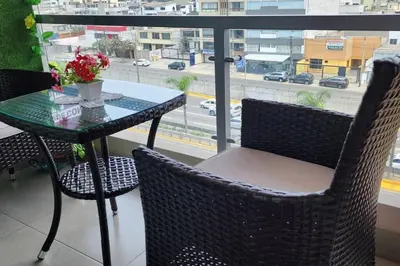 a table and chairs on a balcony with a view of a city at Departamento Zona Céntrica, de estreno in Lima