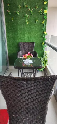 a wicker chair and a table with flowers on it at Departamento Zona Céntrica, de estreno in Lima