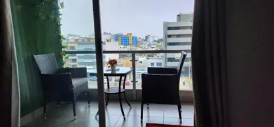 a balcony with a table and chairs and a view of a city at Departamento Zona Céntrica, de estreno in Lima