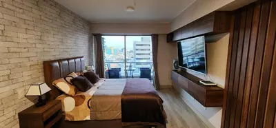 a bedroom with a large bed and a flat screen tv at Departamento Zona Céntrica, de estreno in Lima