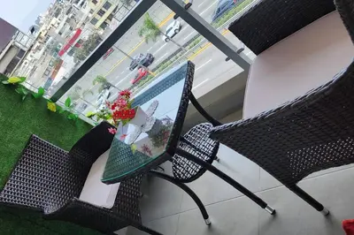 a balcony with two chairs and a table with flowers at Departamento Zona Céntrica, de estreno in Lima